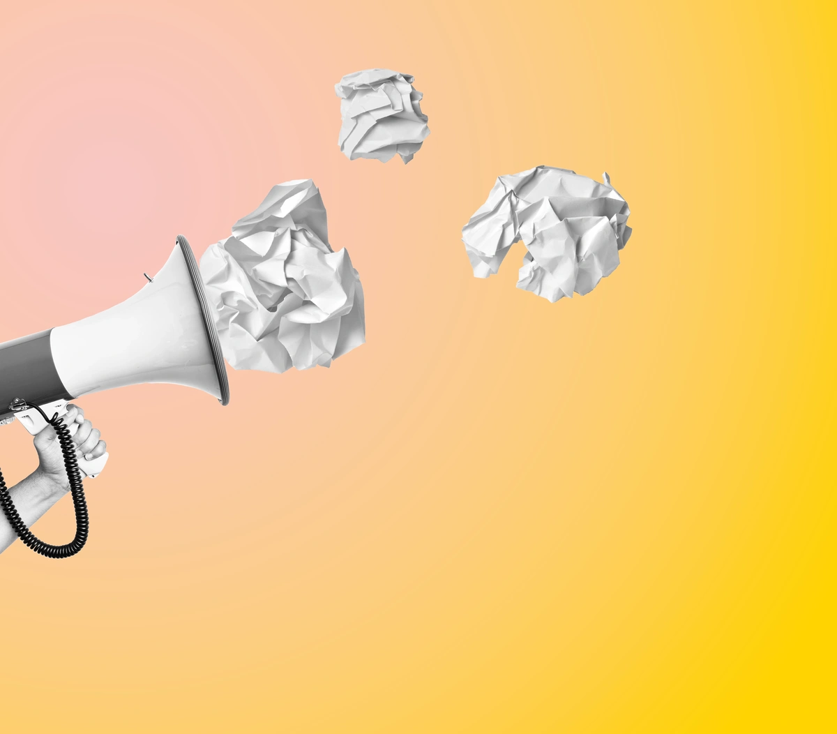Ein Megafon und drei Bälle zerknülltes Papier