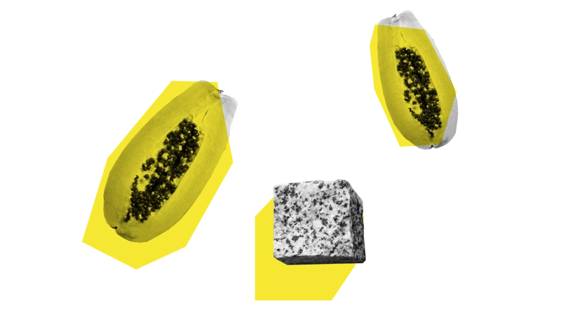 Zwei Papayas und ein Pflasterstein vor gelben Vielecken